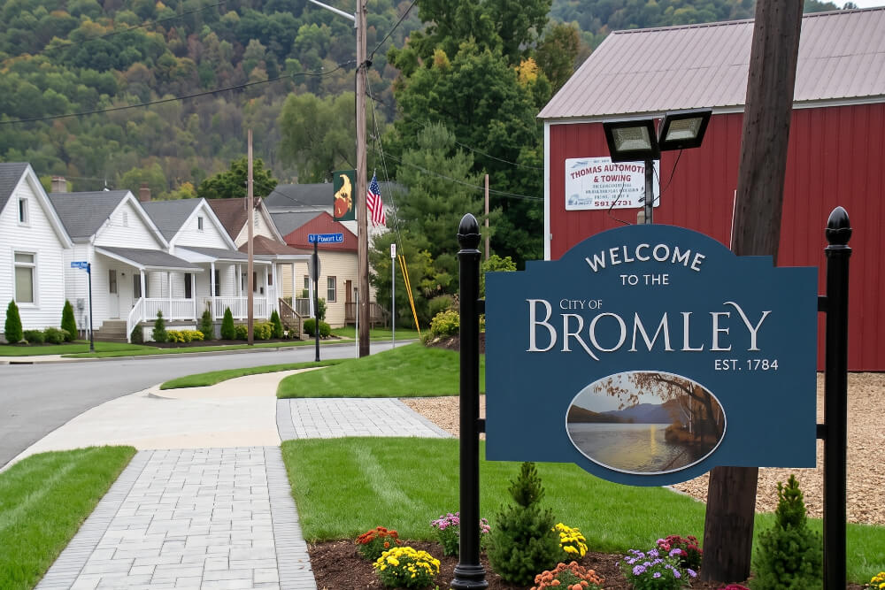 Bromley Kentucky | Pediatrics Of Florence Welcome sign for the City of Bromley along a suburban street with houses and green hills in the background.
