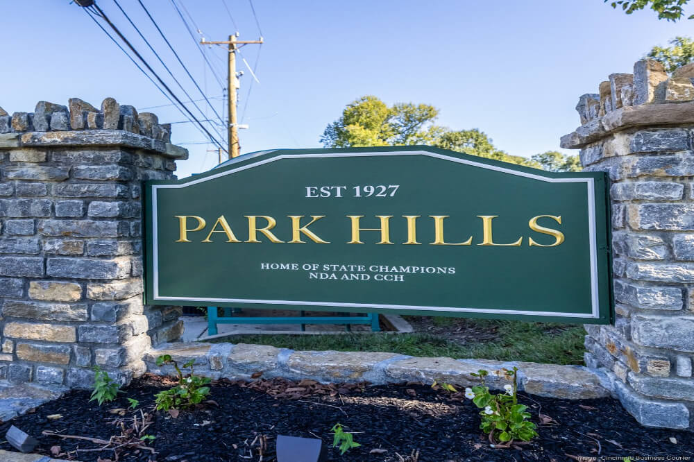 Green Park Hills sign with gold lettering reading EST 1927 and Home of State Champions, flanked by stone pillars at the entrance.